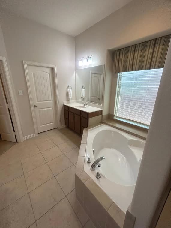 Bathroom with a corner soaking tub and vanity.