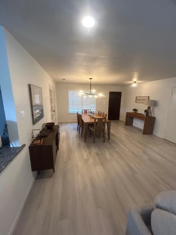 Open-plan living and dining area with light wood floors.