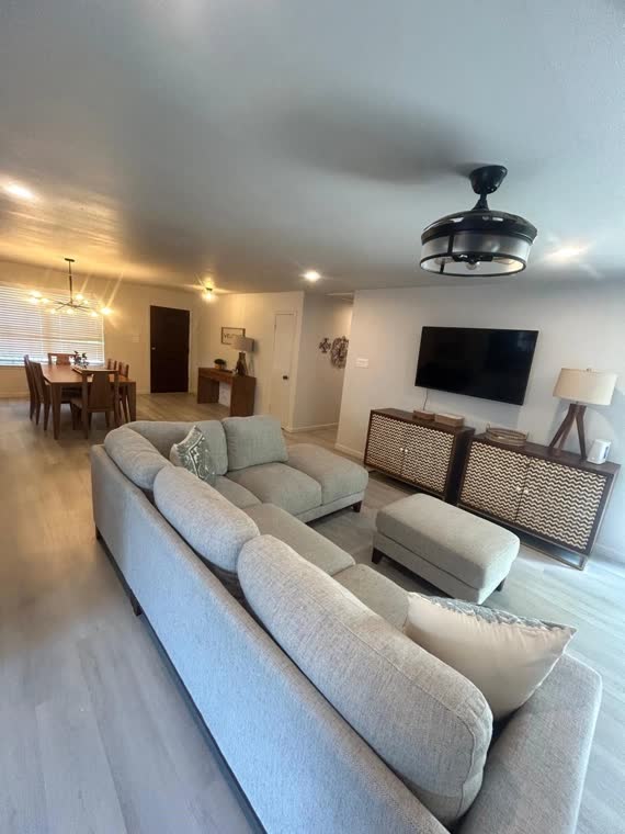 Living room with a large sectional sofa and ceiling fan.